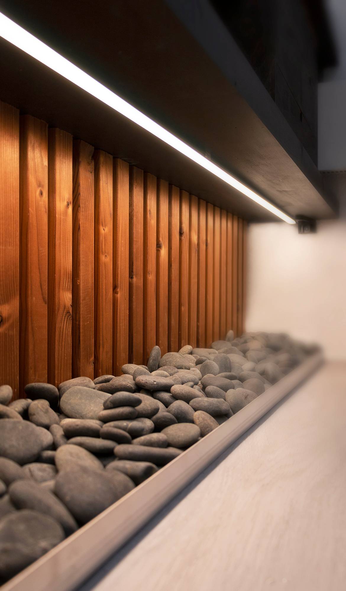 Salle de bains en pierre avec bande LED fixée au bas du niveau. Ledstore.fi